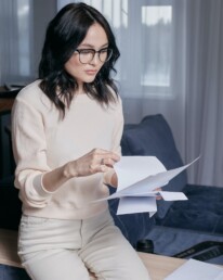 refinance image of woman looking at papers - The Parent Team mortgage loan office